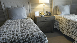 Two twin beds with nightstand and lamp between them in a guest room at Boonespring