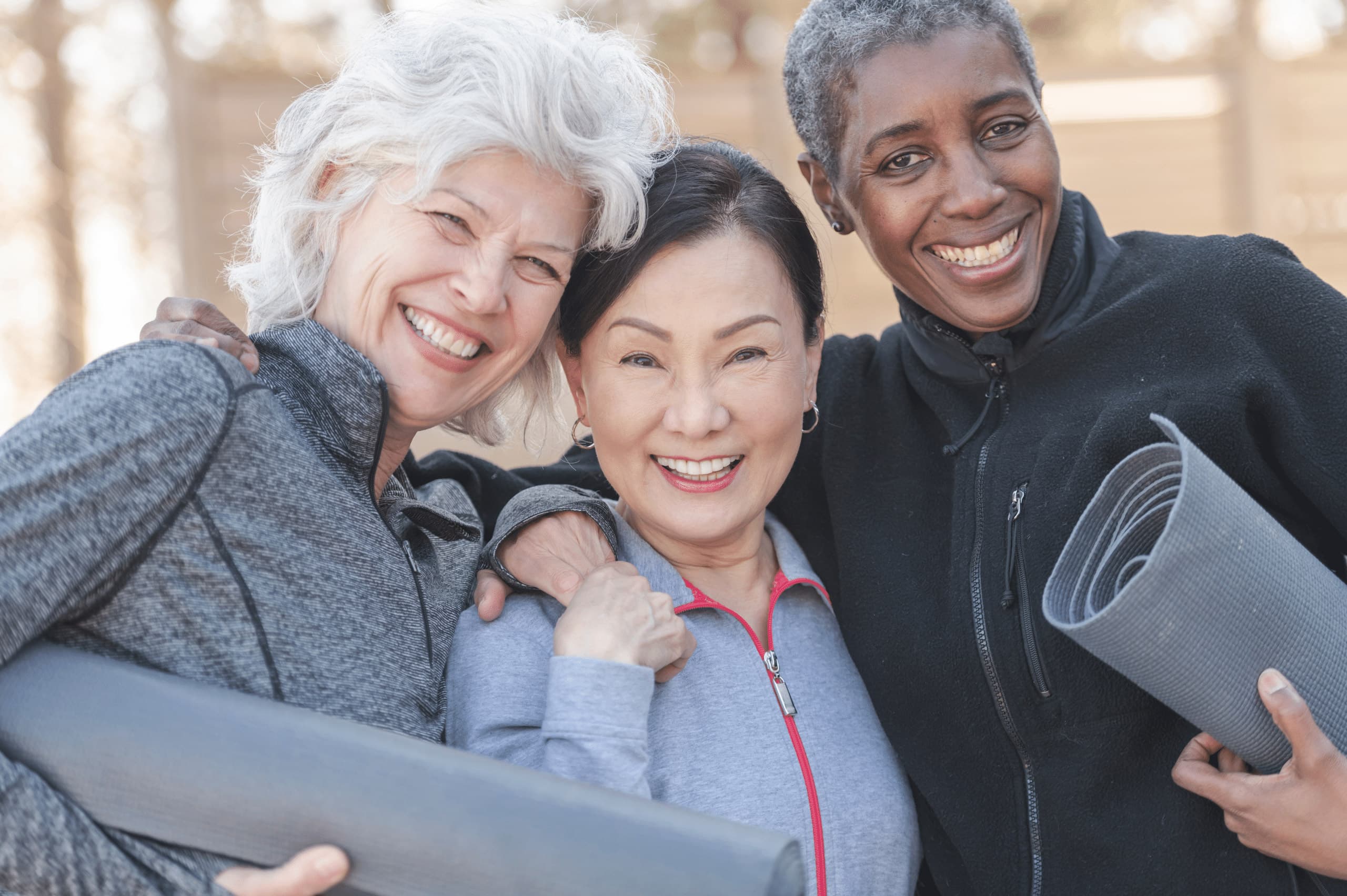 Friends with yoga mats smiling