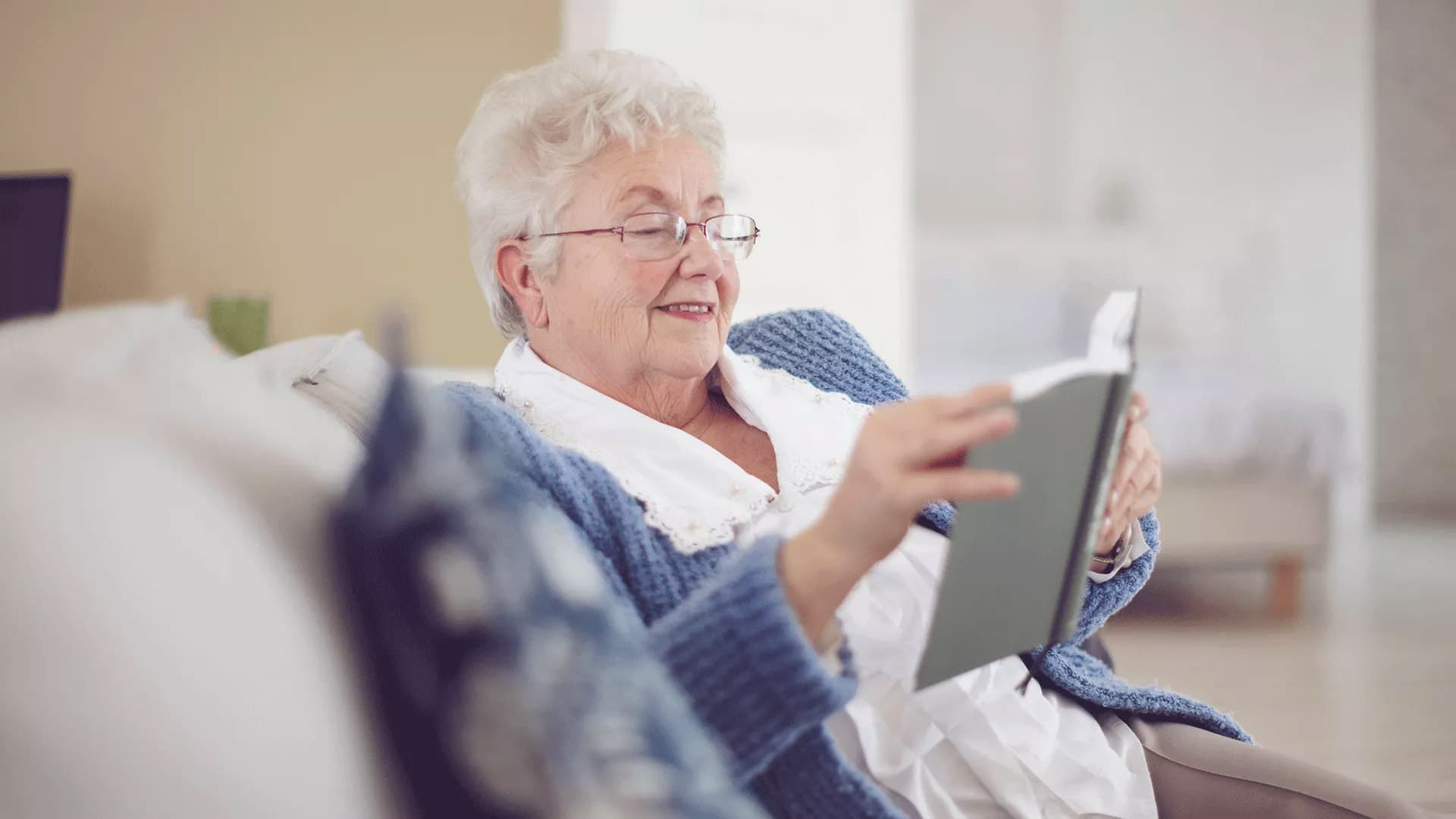 Senior woman reading on couch