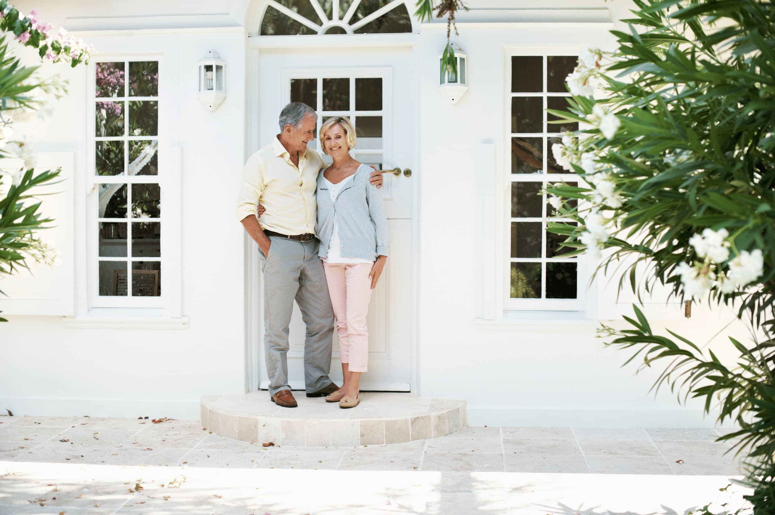 Senior couple standing at doorway smiling