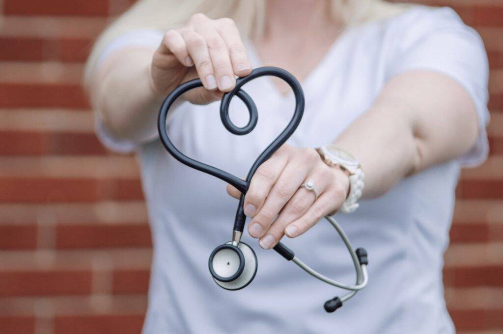 Nurse holding stethoscope in a heart shape