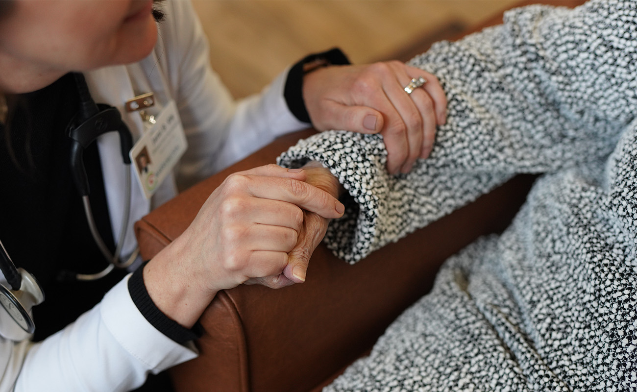 Smiling caregiver interacting with an elderly man at a senior living community.