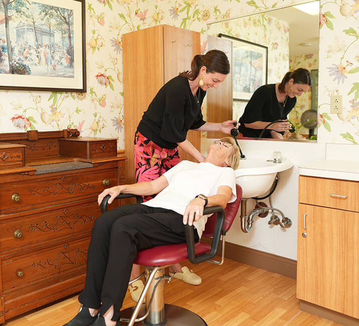 hairdresser doing senior woman's hair