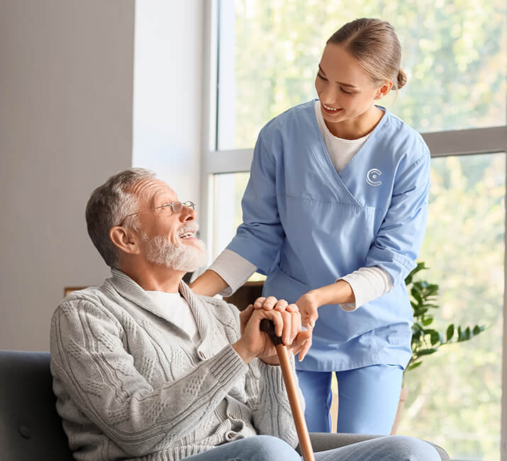 employee helping a man with his cane