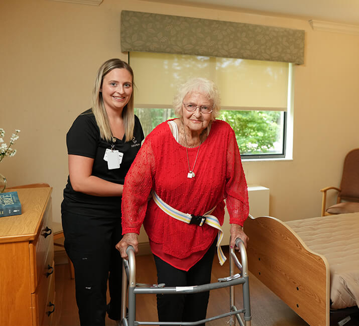 helping senior woman with her walker
