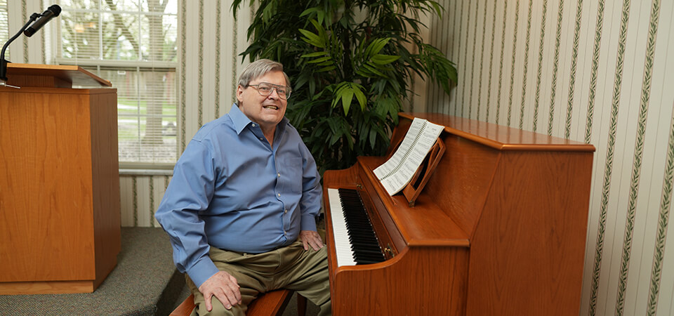 senior man sitting at the piano