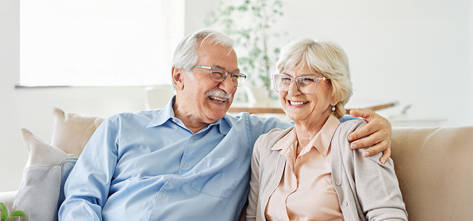 Senior couple laughing on the couch