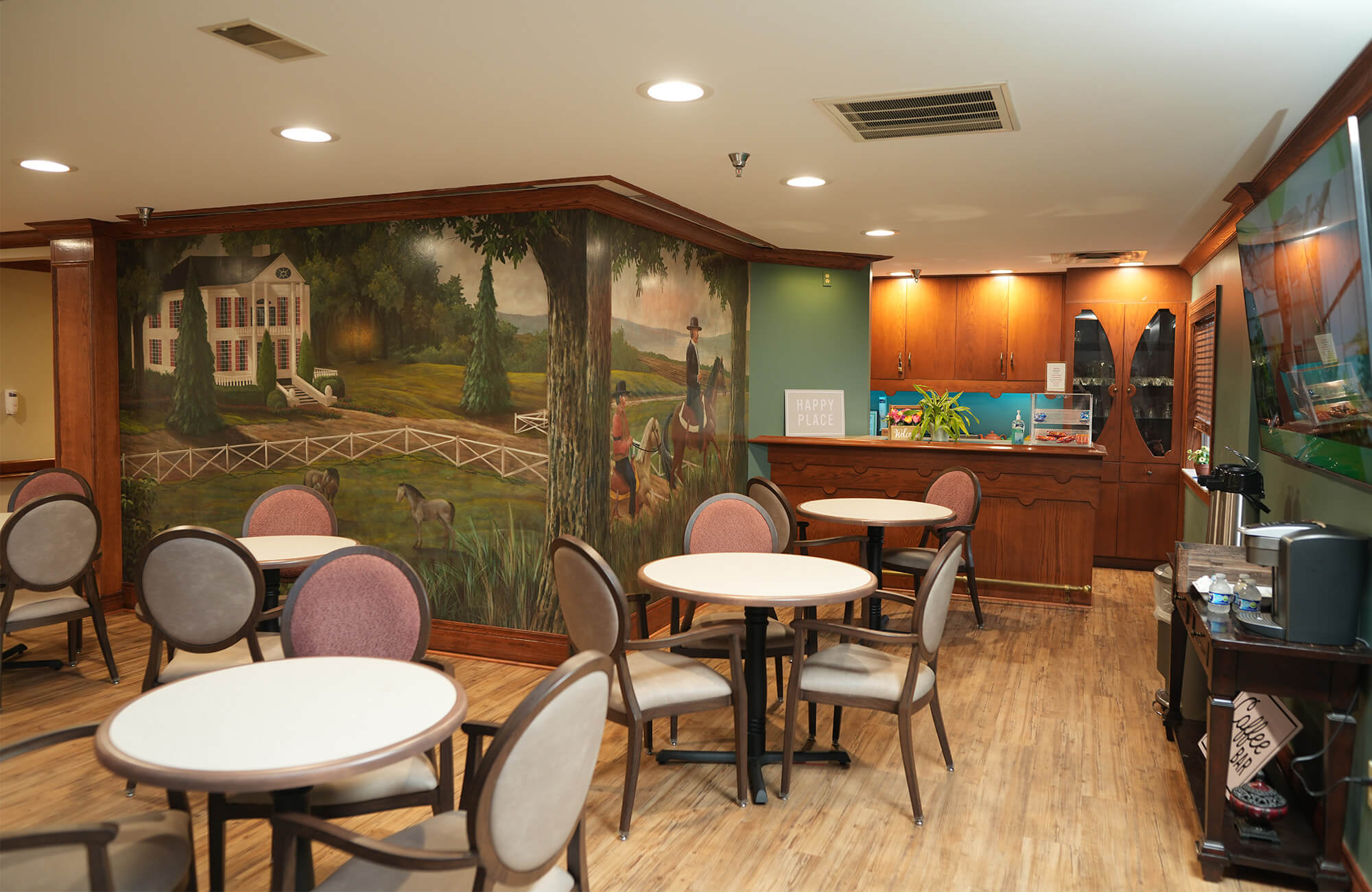 Cozy seating area with mural and wooden cabinet in a communal unit space.