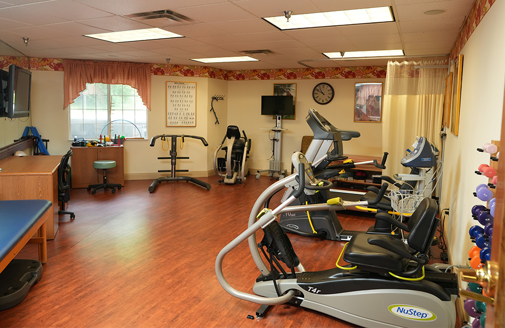 Exercise room with cardio equipment in a senior living community.