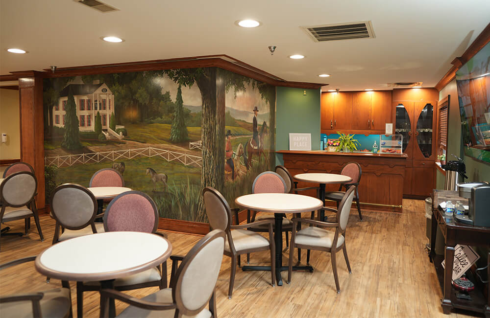 Cozy dining area with mural and round tables in a living community unit.