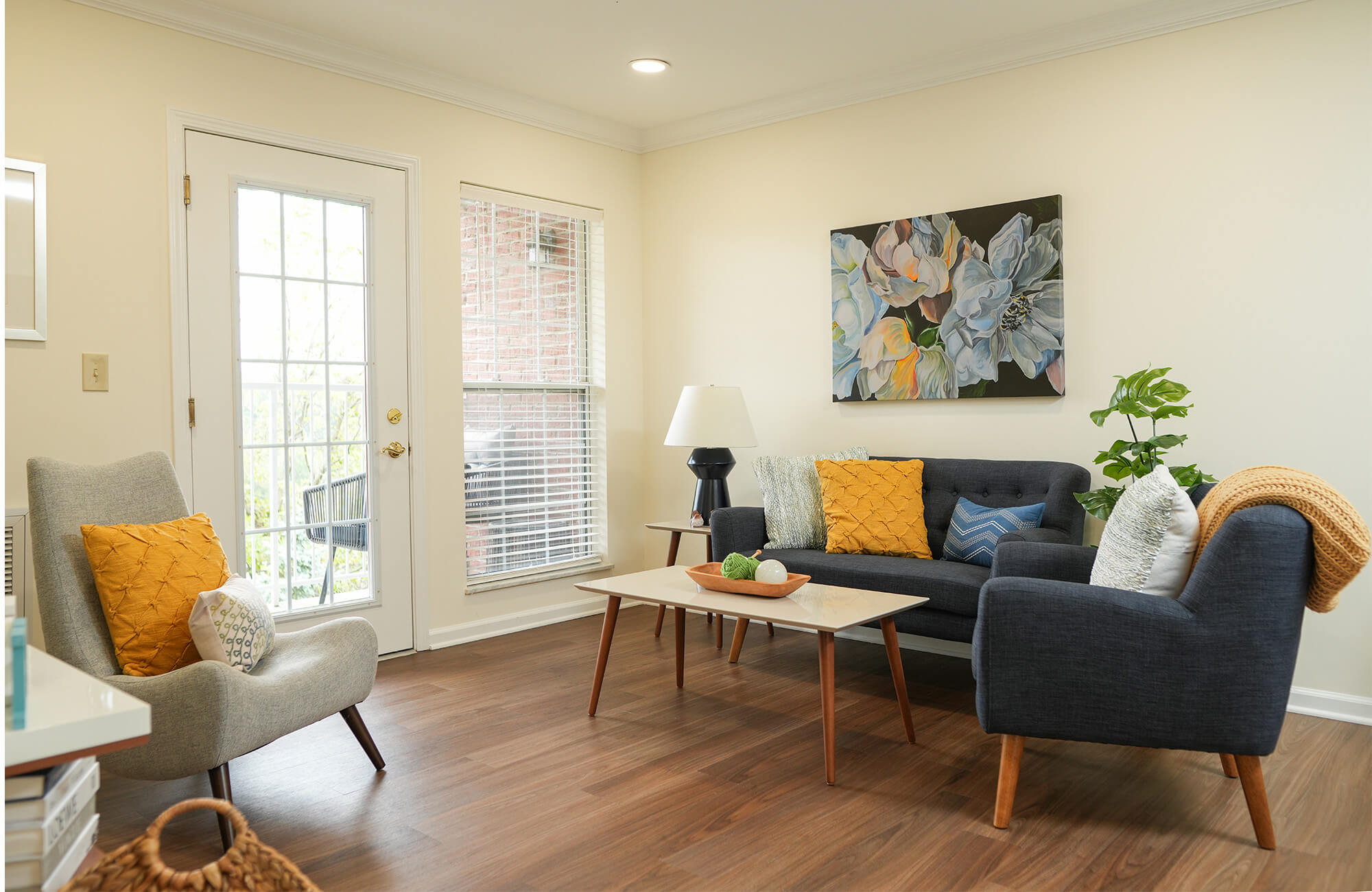 Bright living room with modern furniture and floral artwork on the wall.