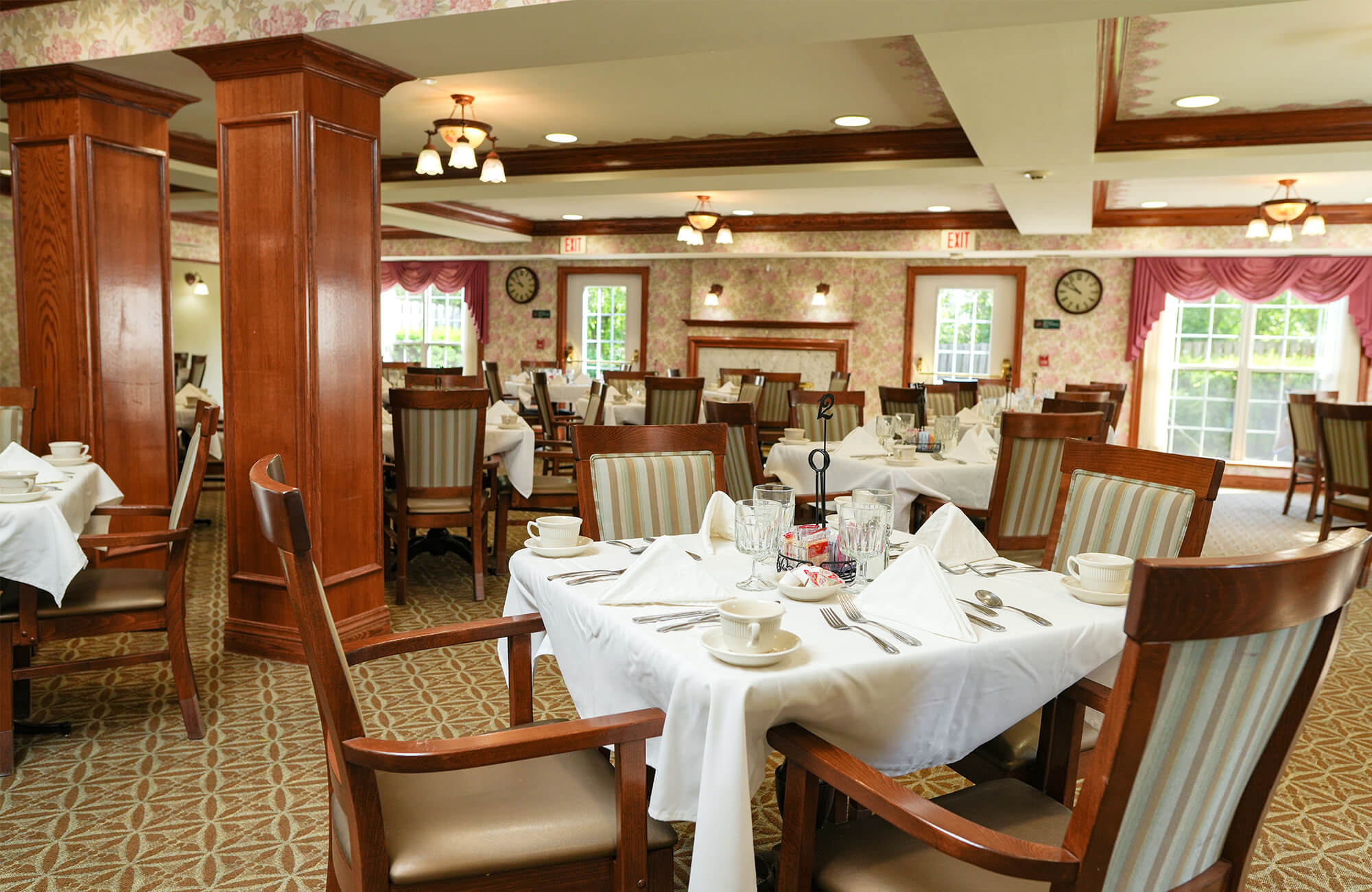 Elegant dining room with neatly set tables in a senior living community.