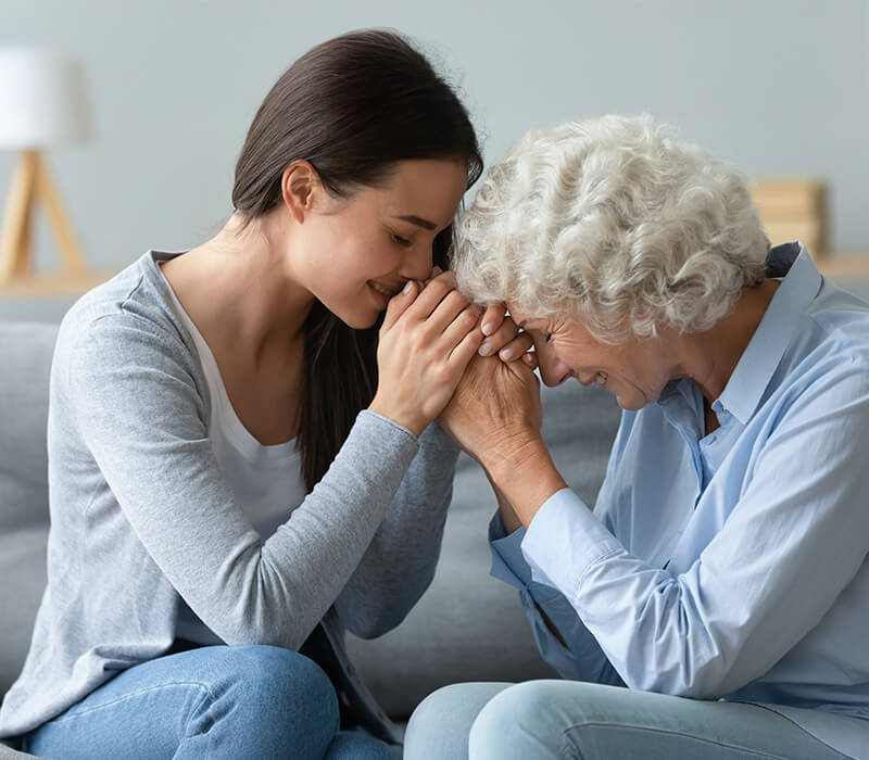 Two women sharing a heartfelt moment in a cozy living space.