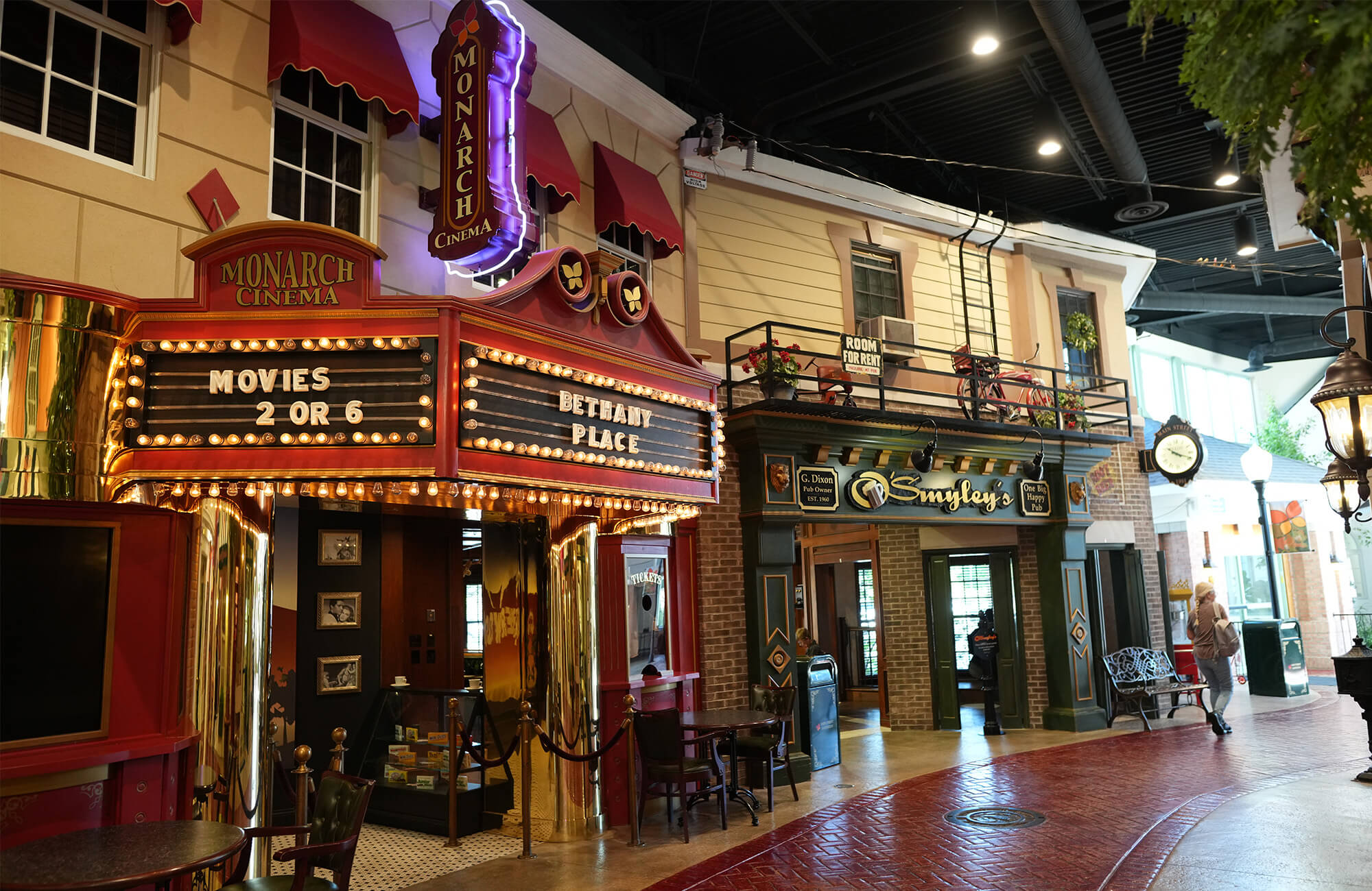 Indoor street scene with cinema and storefronts in senior community living area.