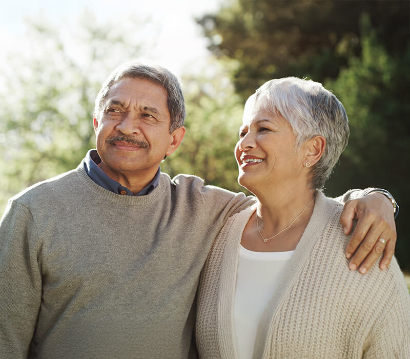 Smiling elderly couple enjoying a sunny day outdoors at the community garden.