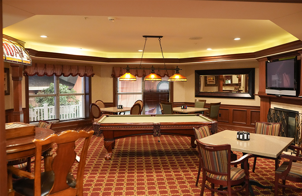 Elegant recreation room with pool table and dining area in a senior community.