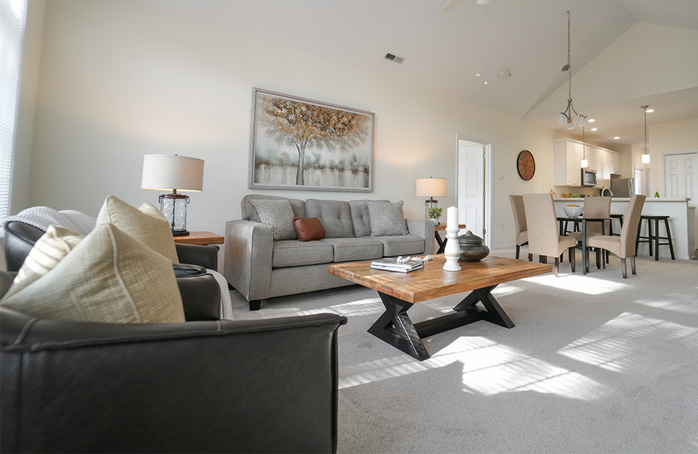 Spacious community area with sofas, chairs, and a TV for residents.
