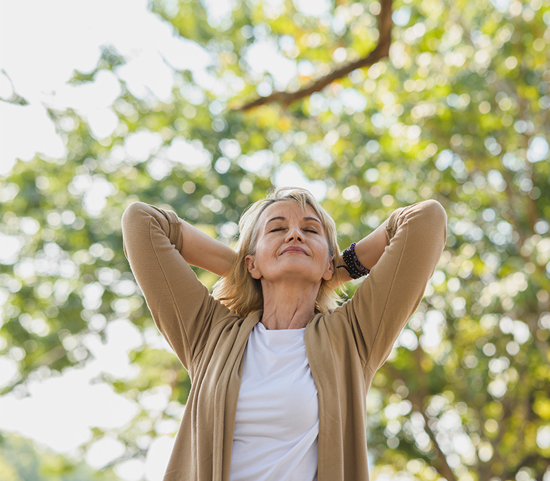 Senior woman taking a breath of fresh air outdoors