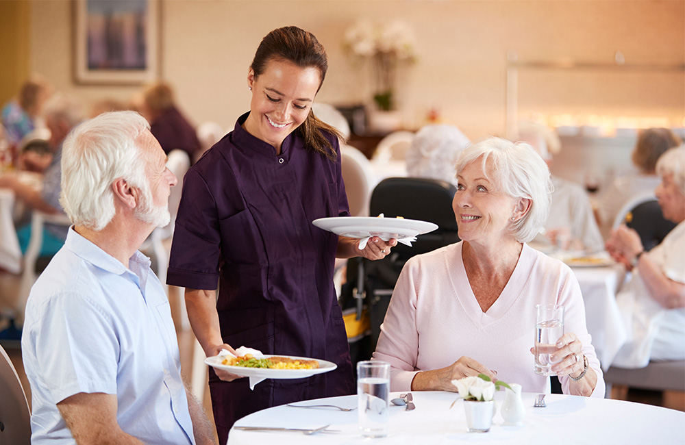 Senior couple being served dinner