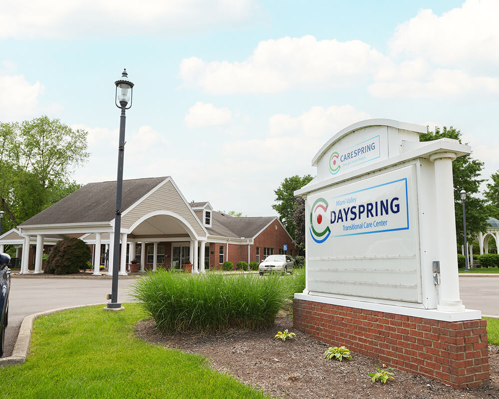 Front entrance of Dayspring Transitional Care Center with main sign and garden.