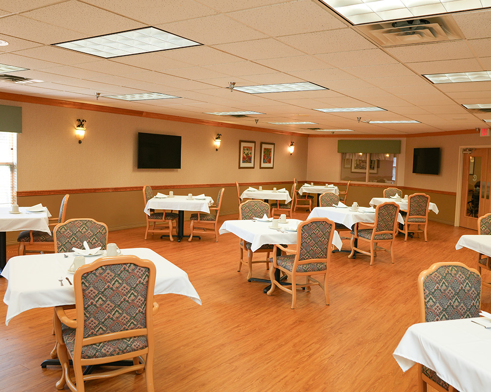 Dining area in senior living community with neatly arranged tables and chairs.