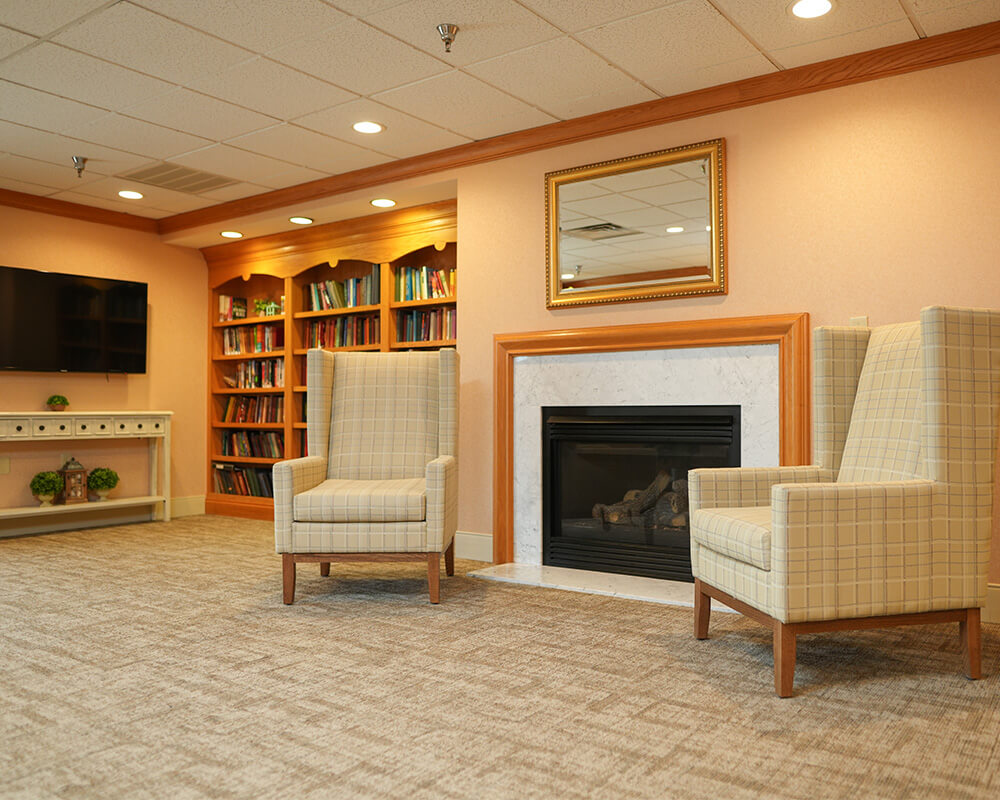 Comfortable lounge area with floral seating, lamps, and a large clock.
