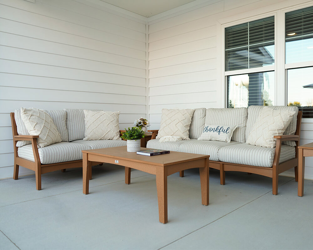 Cozy outdoor seating with beige cushions and potted plant on the patio.
