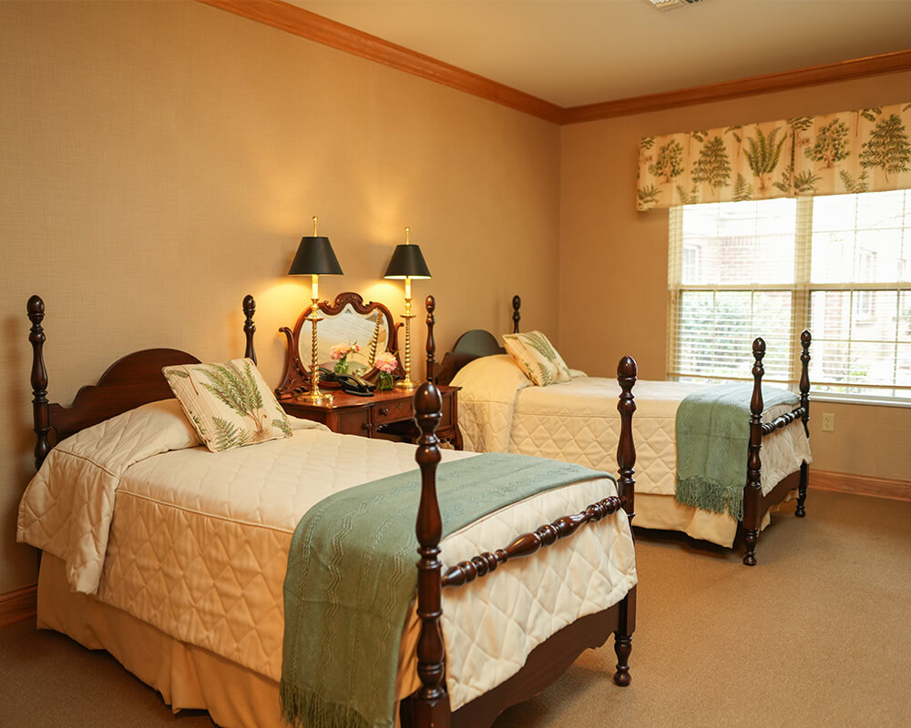 Cozy room with twin beds, wooden furniture, and decorative pillows.