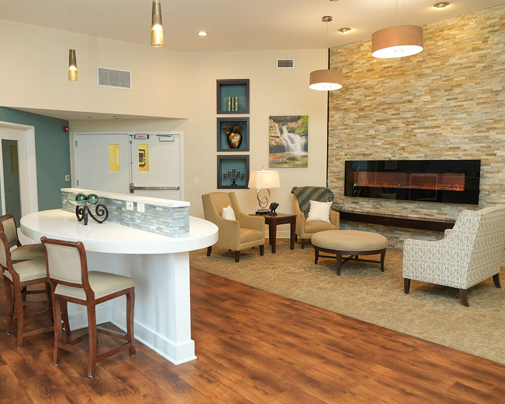 Modern common area with fireplace, chairs, and a small round table.