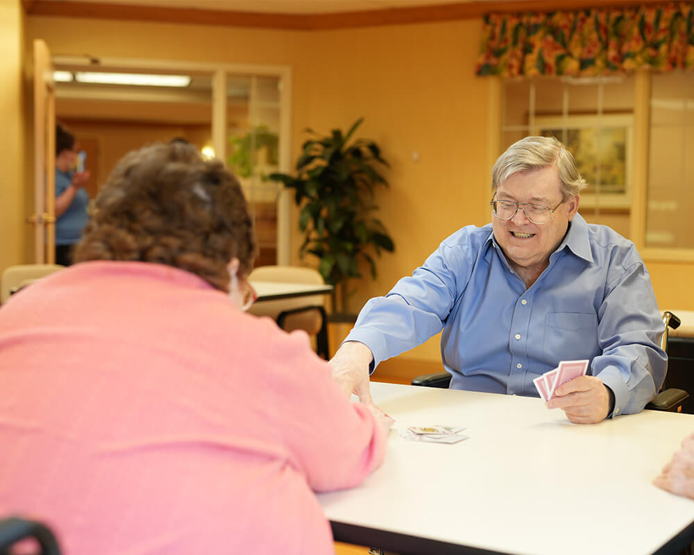 Residents enjoying a card game in a communal area.
