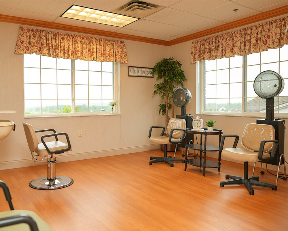 Salon area with chairs and dryers in a senior living community.