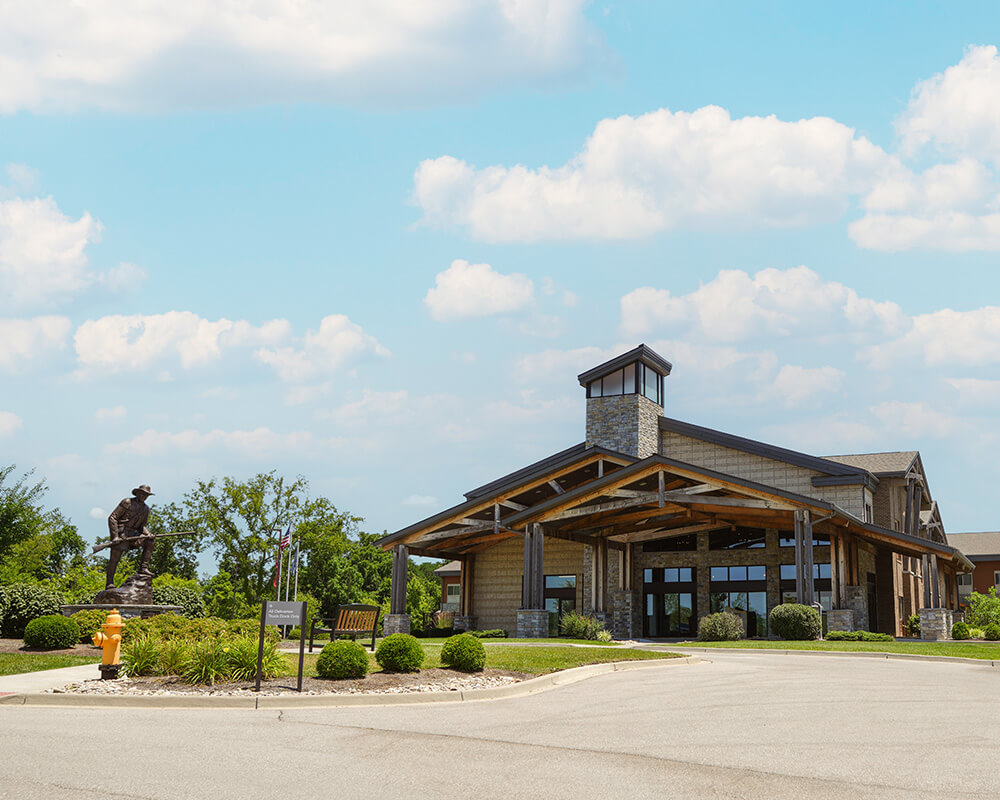 Entrance of a senior living community with large stone and wood exterior.