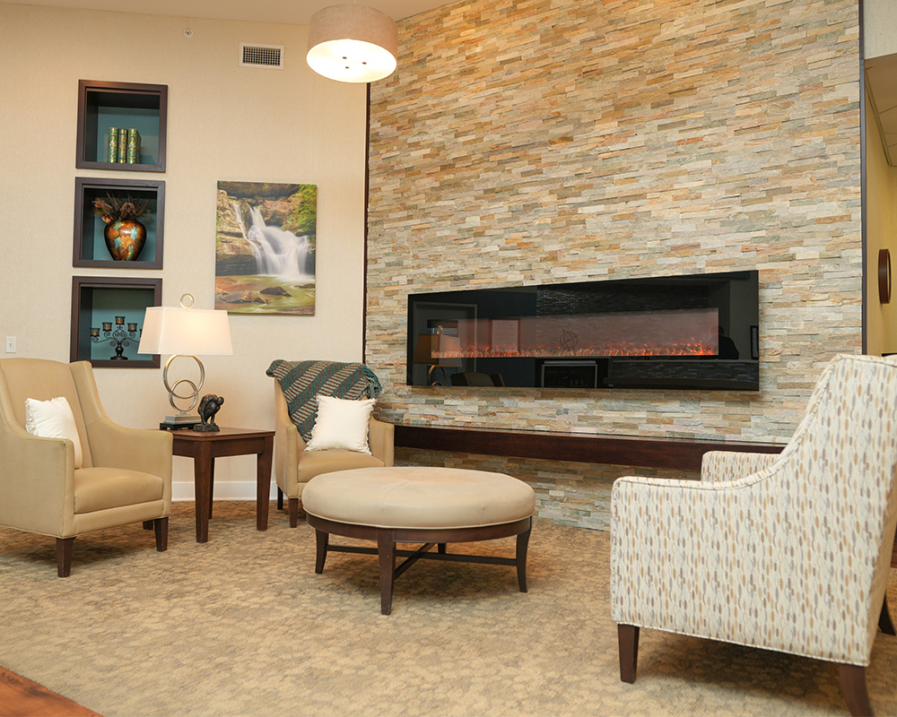 The Atlantes of Eastgate community living space with fireplace and comfortable seating