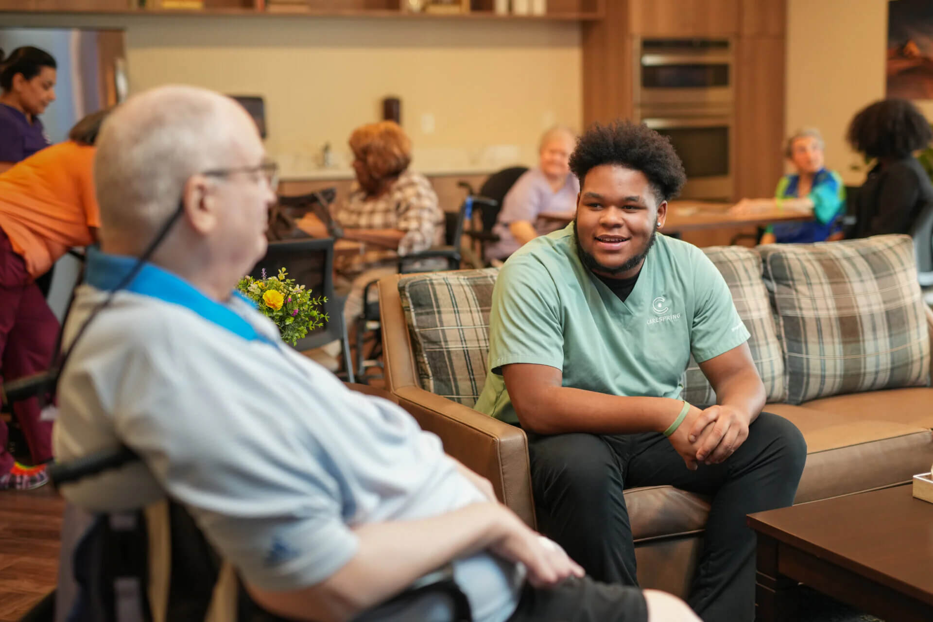 Senior man and young man talk in community room