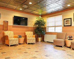 Cozy seating area in the communitys main lounge with armchairs and a TV.