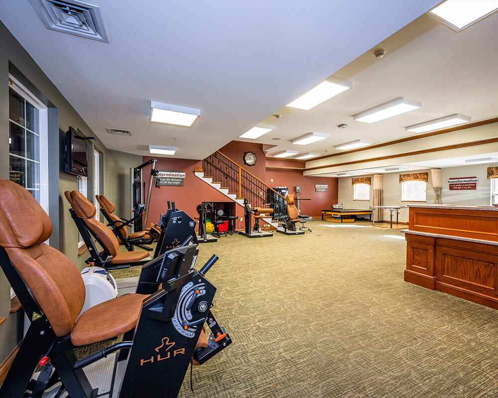 Well-lit fitness area with exercise equipment and comfortable seating for residents.