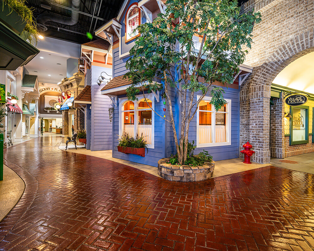 Charming indoor street scene with vibrant building facades and trees.