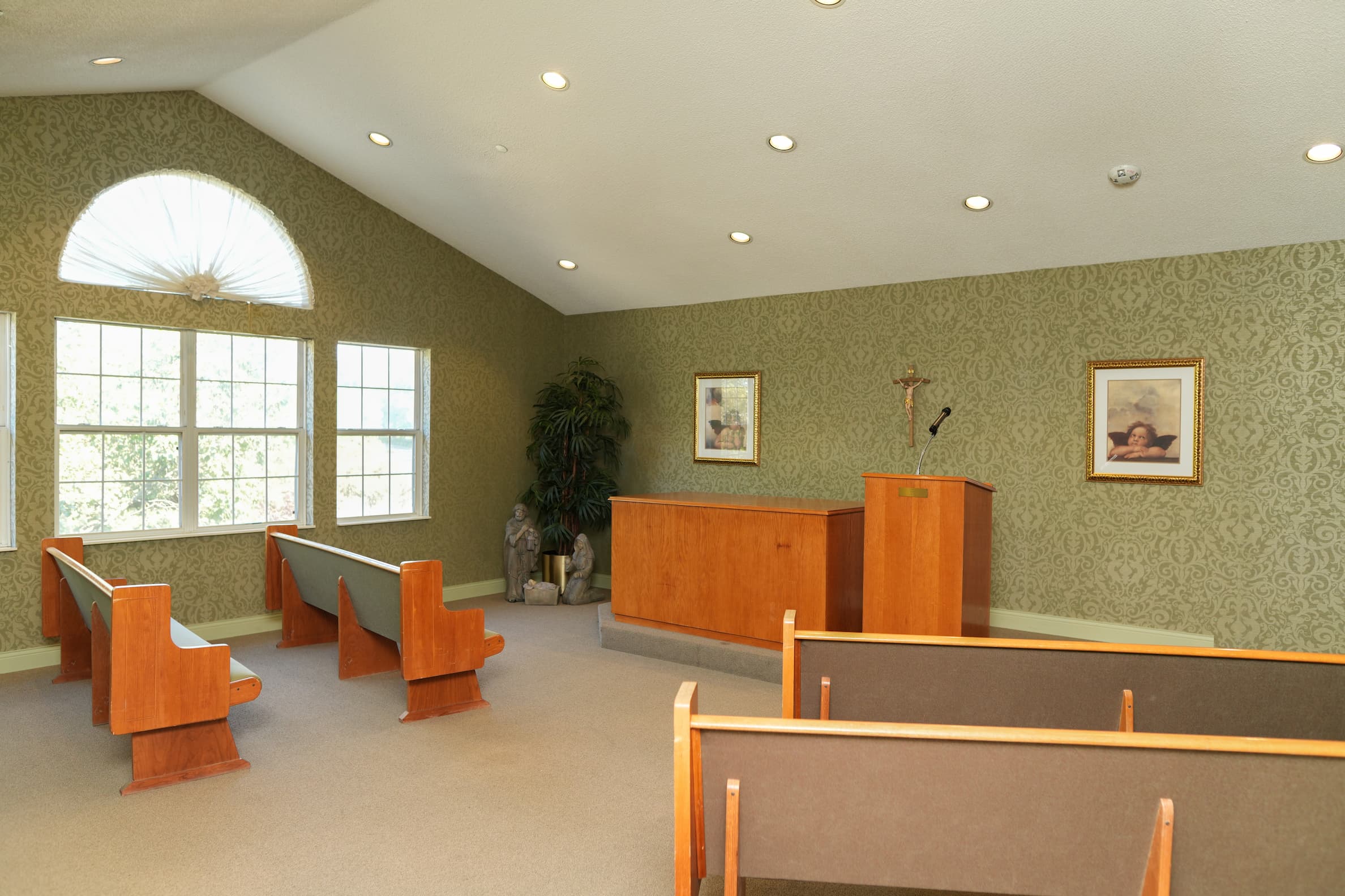 Chapel room with wooden pews and a lectern inside a senior living community.