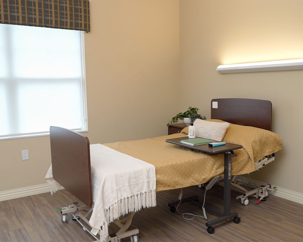 Comfortable, modern unit with a single bed, side table, and window light.