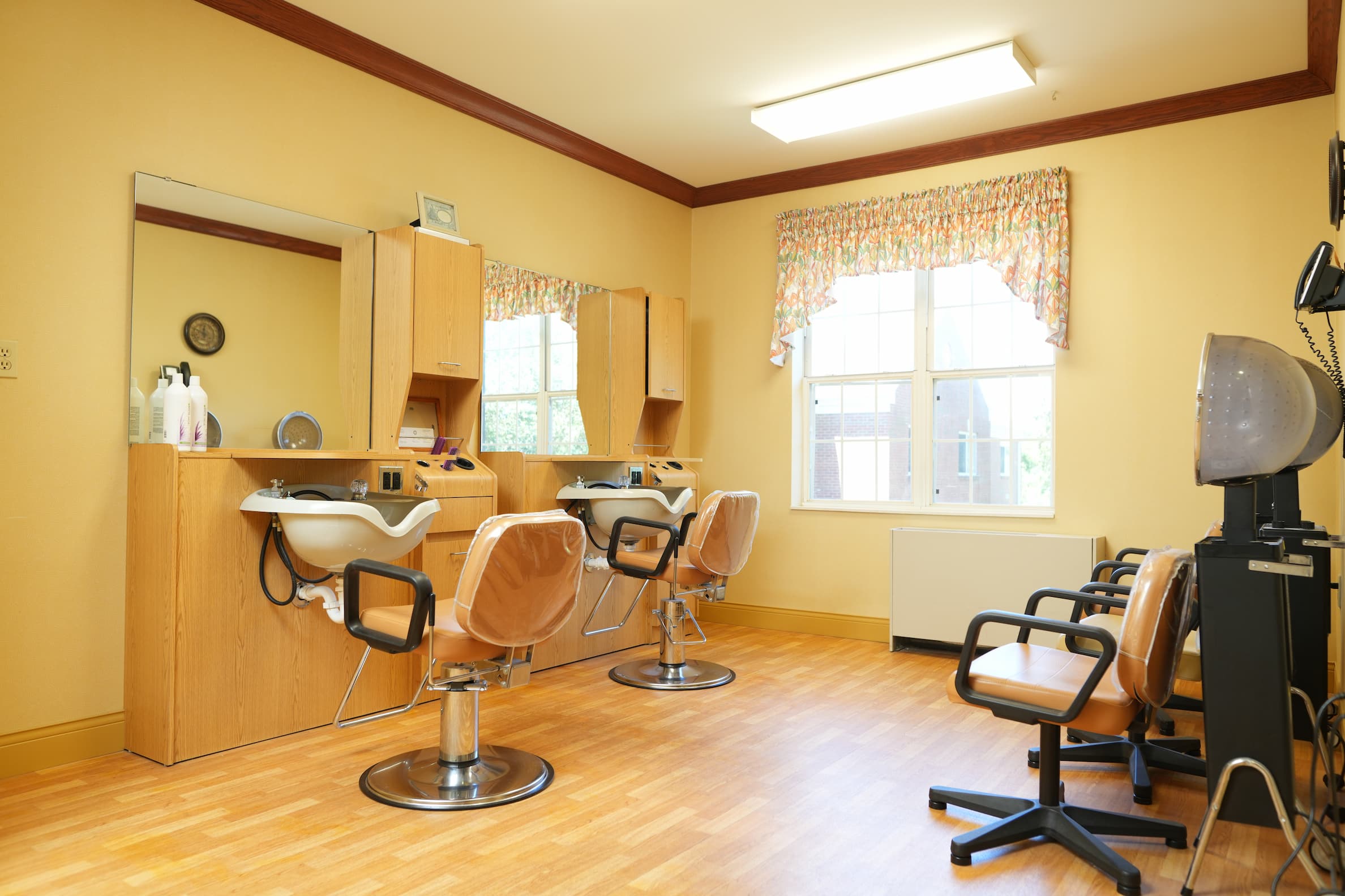 Bright salon area with chairs and washing stations in a community setting.