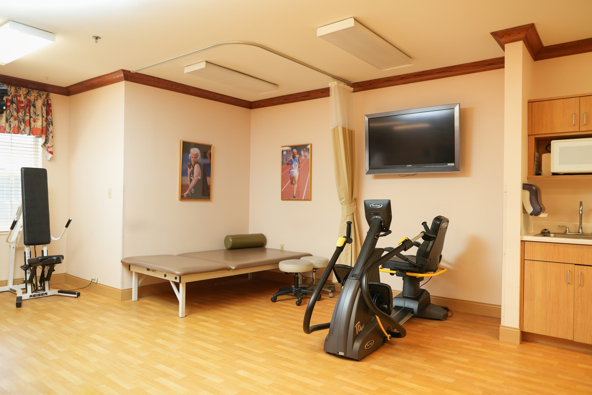 Exercise room with gym equipment in a senior living unit.