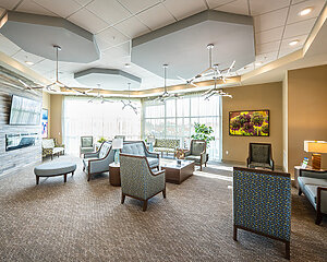 Spacious community unit living room with modern furniture and large windows.