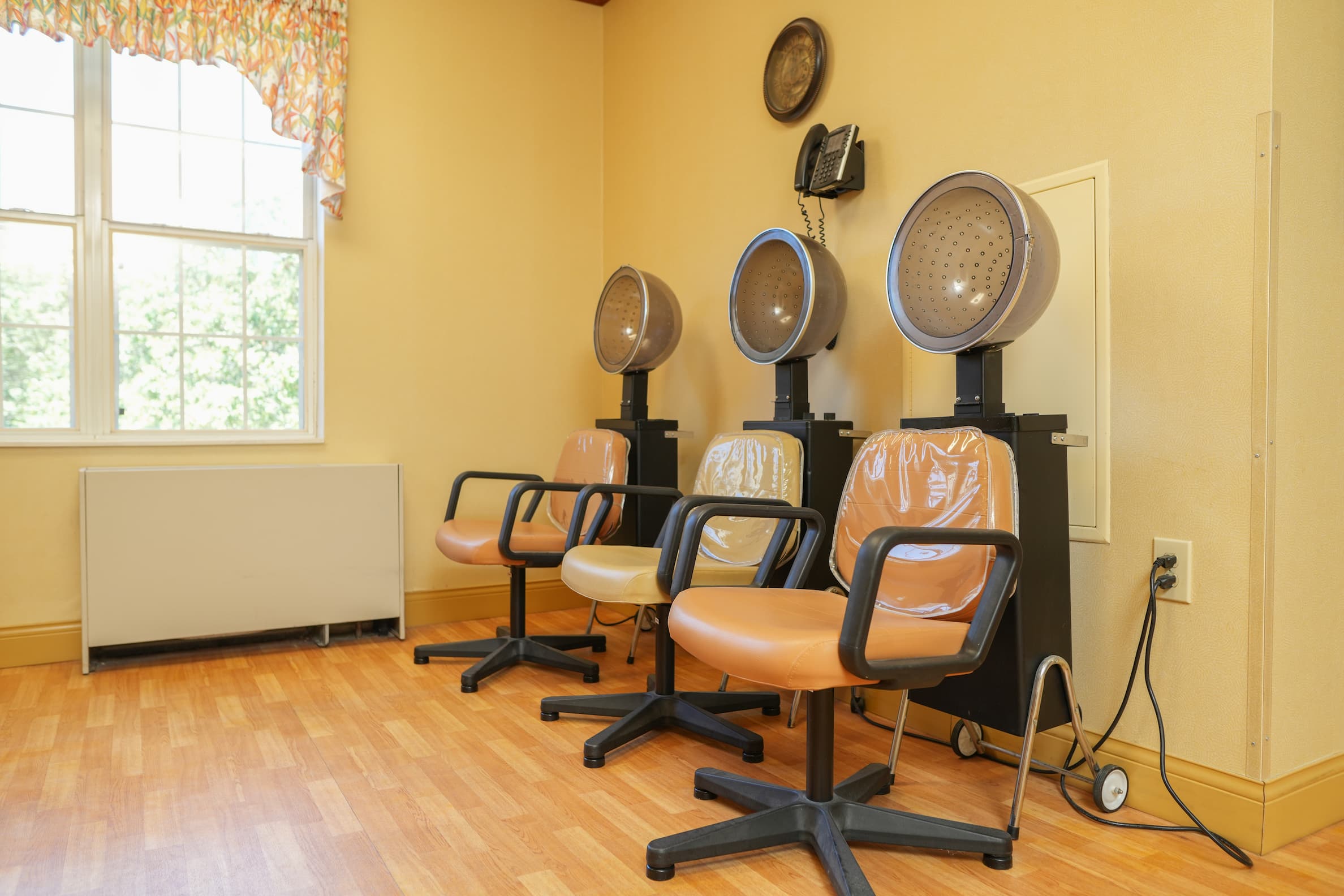 Hair salon with three hair drying stations inside a senior living community.